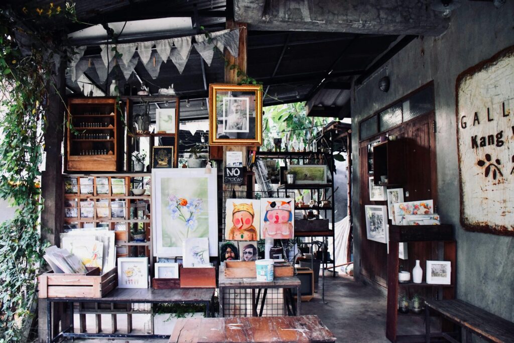 Art studio with diverse paintings and prints on display in a charming rustic setting.